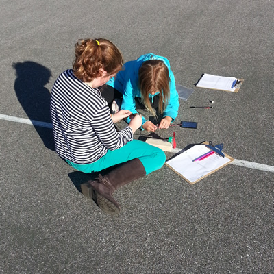 Photograph of two students working outside.