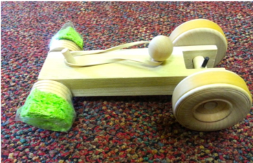 Photo of a toy car with a sponges attached to its wheels.