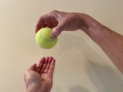 A photograph of transferring a ball from one hand to another.