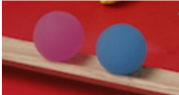 Close up photograph of a red ball and a blue ball.